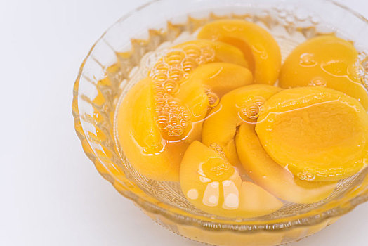 玻璃碗中的黄桃罐头特写