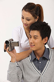 情侣拿着数码录像摄像机
