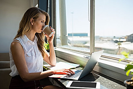 职业女性,喝咖啡,使用笔记本,窗户,办公室