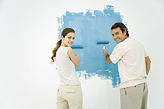 情侣,上油漆,墙壁,蓝色,滚筒,看,上方,肩部,看镜头,微笑