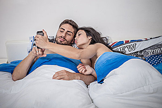 年轻,情侣,智能手机,床上