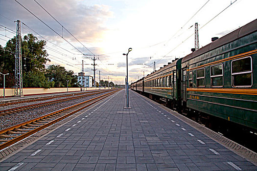 空旷的火车站台和延伸的铁轨和绿皮火车