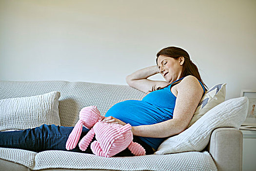 侧面视角,孕妇,拿着,粉色,毛绒玩具,闭眼,休息,沙发