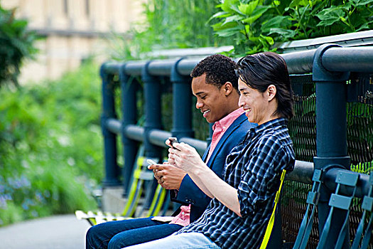 两个男人,城市公园,长椅,发短信