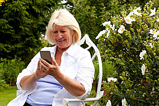 老年,女人,坐,花园,看,智能手机