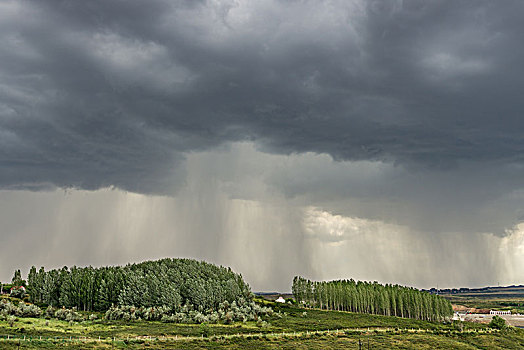 阴天积雨云下的山坡草原村庄