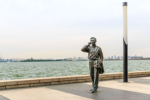 中国江苏省苏州金鸡湖湖畔男人休闲散步雕塑