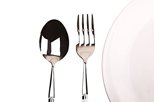 摆放整齐的白色盘子银色叉子和勺子