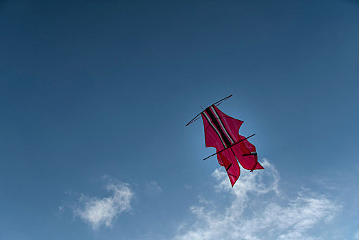 巴厘岛金巴兰海滩蓝天上的红色风筝