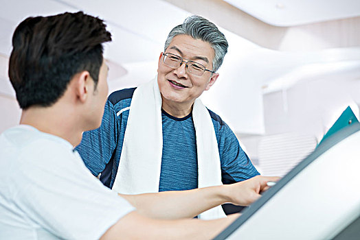 老年男子和年輕男子在健身房健身