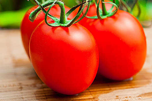 新鲜的西红柿在木质的砧板上,阳光下更加自然和美味