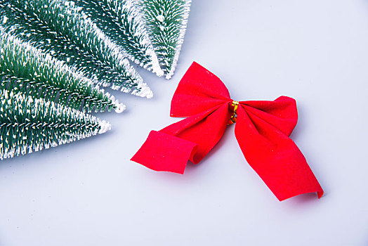 小型圣诞树雪松围绕在红色的蝴蝶结周围