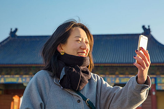 旅行时使用智能手机自拍的女人