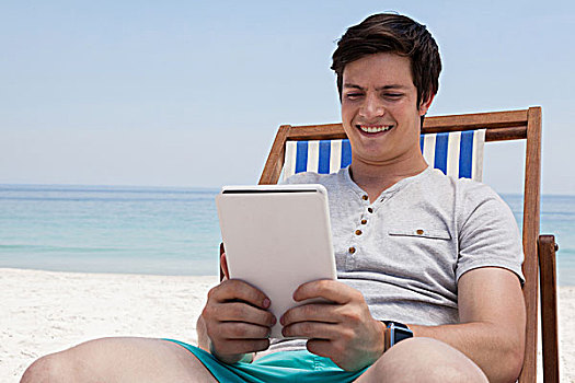 男人,坐,太阳椅,数码,海滩,微笑