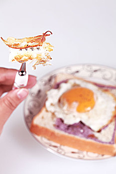 特写用叉子吃煎鸡蛋配面包