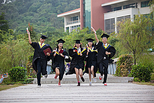 五个身穿学士服的大学生在校园奔跑