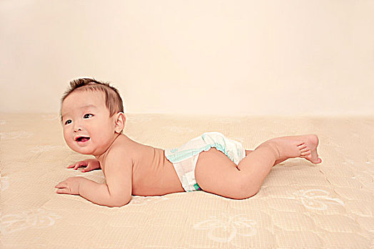 一名7个月大的男婴趴在床上