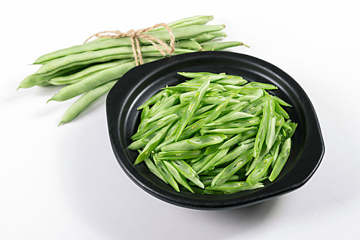 保健蔬菜一盘四季豆丝和一捆四季豆摆放在桌面上