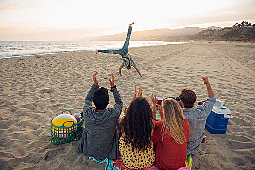 群体,朋友,坐,海滩,看,侧手翻,日落,后视图