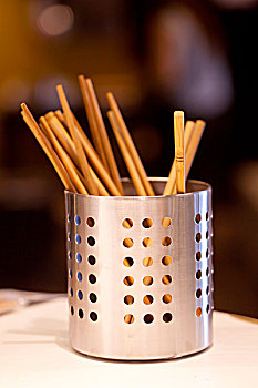 钢制圆形镂空的筷子桶中放着木制筷子