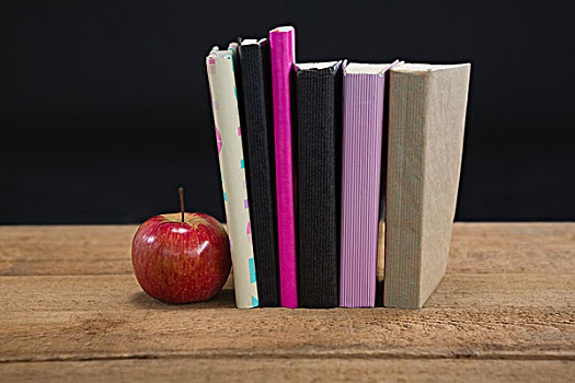 苹果,书本,木桌子,黑色背景