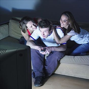 两个女人,一个,男人,坐,沙发,看电视,足球,衬衫,遥控