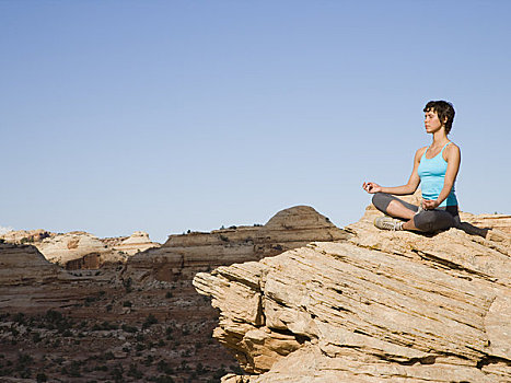 坐,女人,双腿交叉,岩石上,户外,瑜珈
