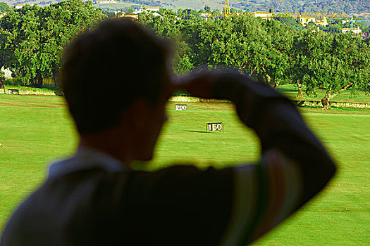 后视图,中年,男人,遮眼,看,高尔夫球场,背景聚焦
