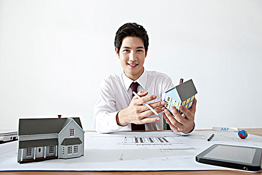 商务人士,拿着,房屋模型,书桌