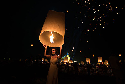 泰国清迈水灯节活动,一名女性正在放飞点燃的天灯