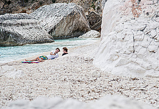 男青年,放松,岩石,海滩,智能手机,萨丁尼亚,意大利