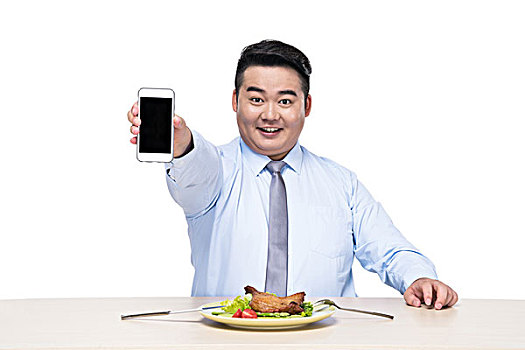 胖子在拿着手机吃饭