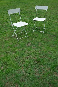 草地上的两把白色椅子
