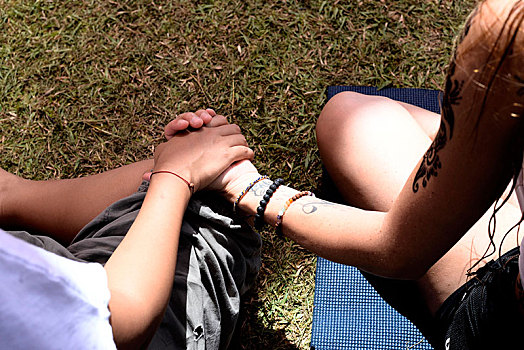 两个女人,握手,坐,双腿交叉,草地