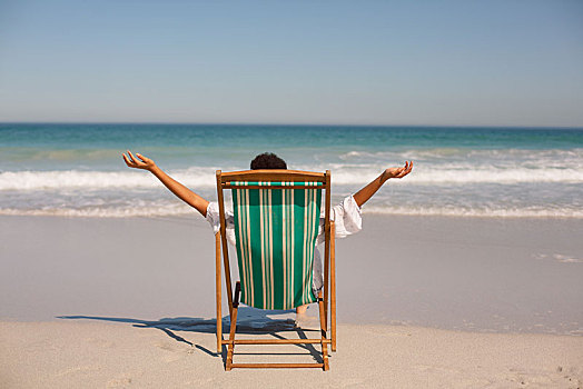 女人,手臂,伸展,室外,坐,沙滩椅,海滩,阳光