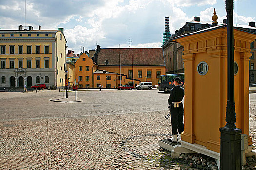 瑞典王宫侧门,卫兵们身穿军服,斜挎着冲锋枪,站在哨位上
