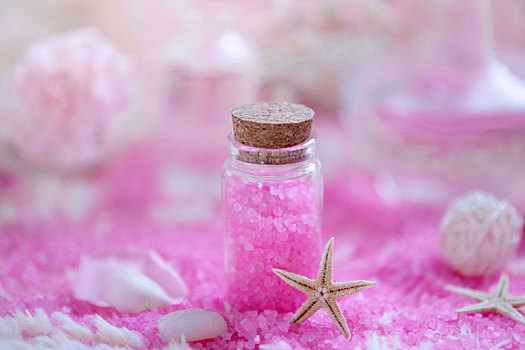 放在桌子上的粉色浴盐和蜡烛