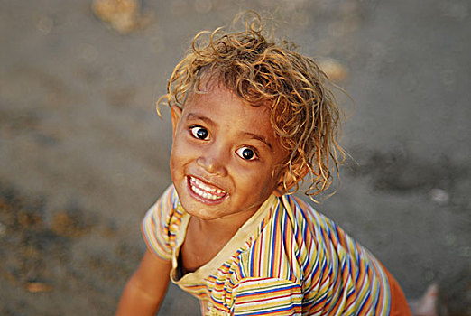 portrait,of,dark,skinned,boy,with,long,curly,hair,and,blond
