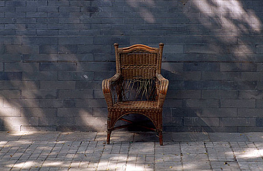 北京什刹海后海墙下放着的一把藤椅