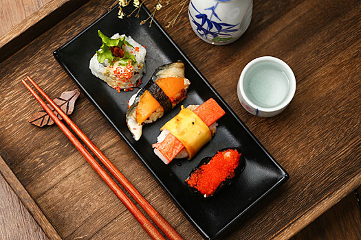 寿司拼盘和日本清酒放在木托盘里