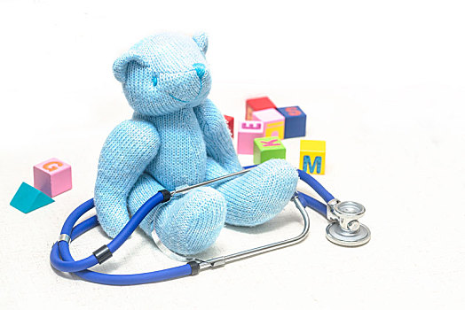 地板上毛绒玩具熊,听诊器与积木,寓意儿童健康,医疗保健概创意图