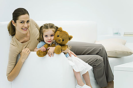 母女,坐,沙发,女人,微笑,看镜头,女孩,拿着,泰迪熊