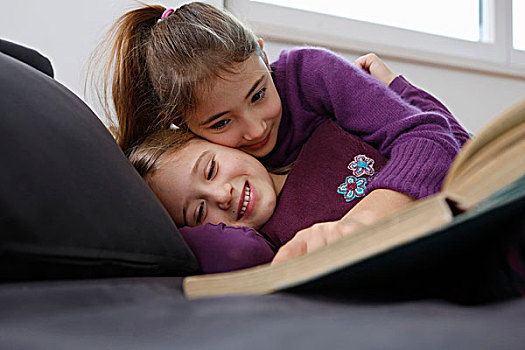 贴地拍摄,风景,女孩,躺下,沙发,读,书本,搂抱,微笑