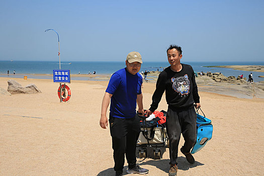 山东省日照市,90后小伙潜水捞海鲜上岸,游客蜂拥而至看稀罕
