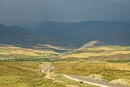 阴天积雨云下的山坡草原村庄