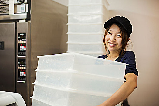 女人,工作,糕点店,戴着,棒球帽,一堆,白色,塑料制品,板条箱