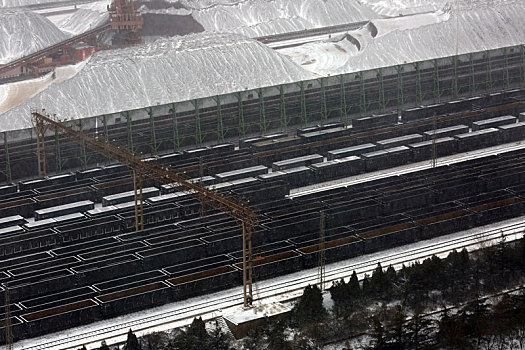 山东省日照市,狂风暴雪席卷港城,港口生产受阻,红色矿石堆场变身,雪山