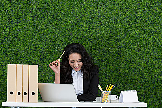草地商务女性使用笔记本电脑