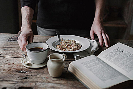 一个人,桌子,一杯咖啡,碗,牛奶什锦早餐,翻书