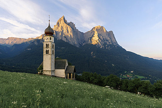 意大利多洛米蒂山间的教堂与远方清晨的高原山峰